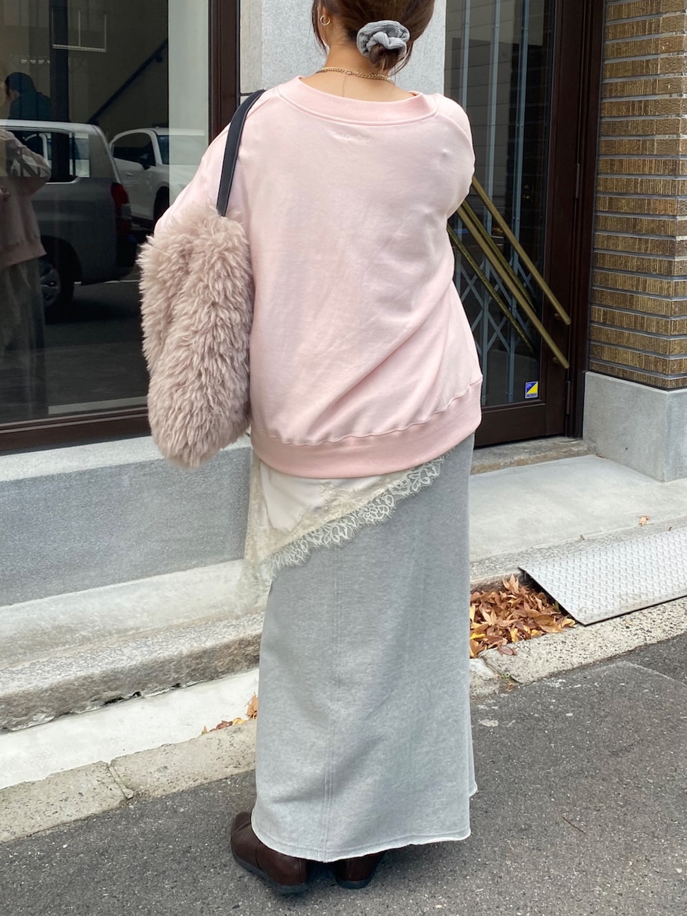 ピンク系のスウェット、ベージュ系のキャミソール、グレー系のスカートを着用したレディースの冬コーディネートの7枚目の写真