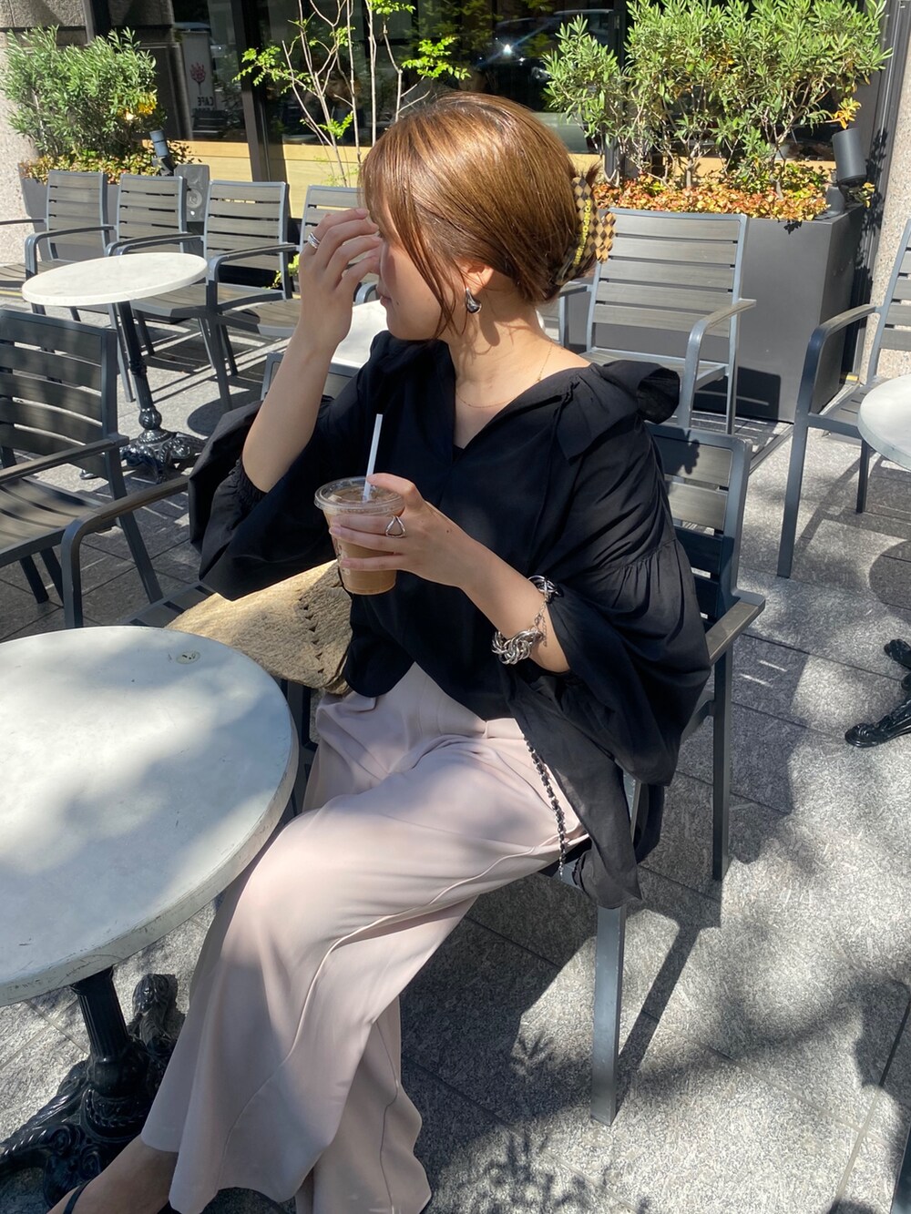 ブラック系のシャツ/ブラウス、ピンク系のスラックス、シルバー系のベルトを着用したレディースの夏コーディネートの5枚目の写真