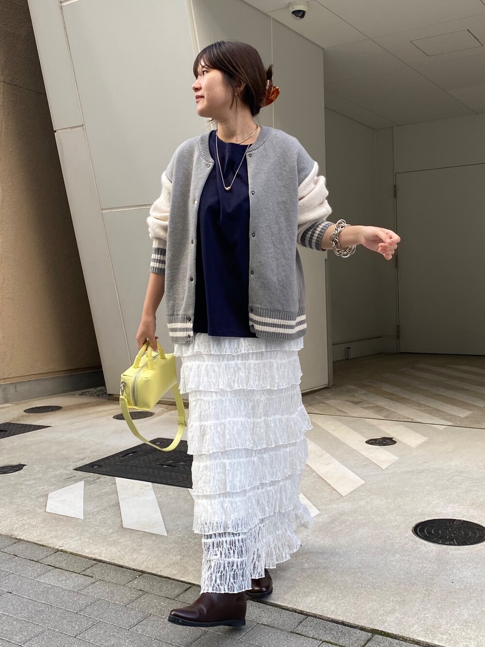 グレー系のその他アウター、ブルー系のTシャツ/カットソー、ホワイト系のスカートを着用したレディースの冬コーディネートの7枚目の写真