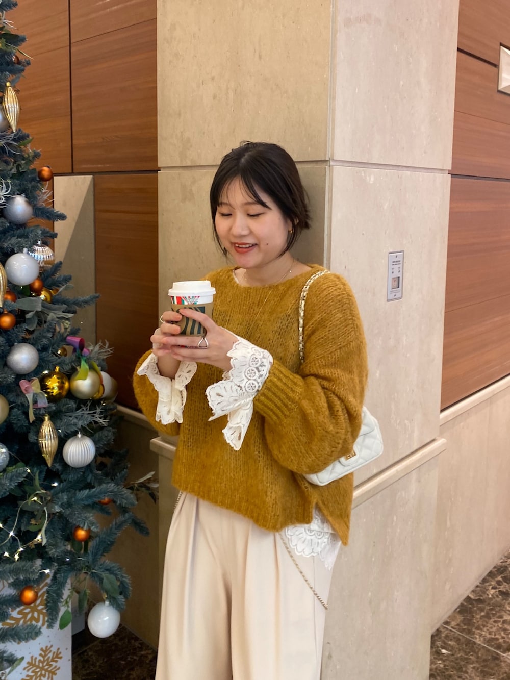 ベージュ系のその他アウター、イエロー系のニット/セーター、ホワイト系のシャツ/ブラウスを着用したレディースの冬コーディネートの7枚目の写真