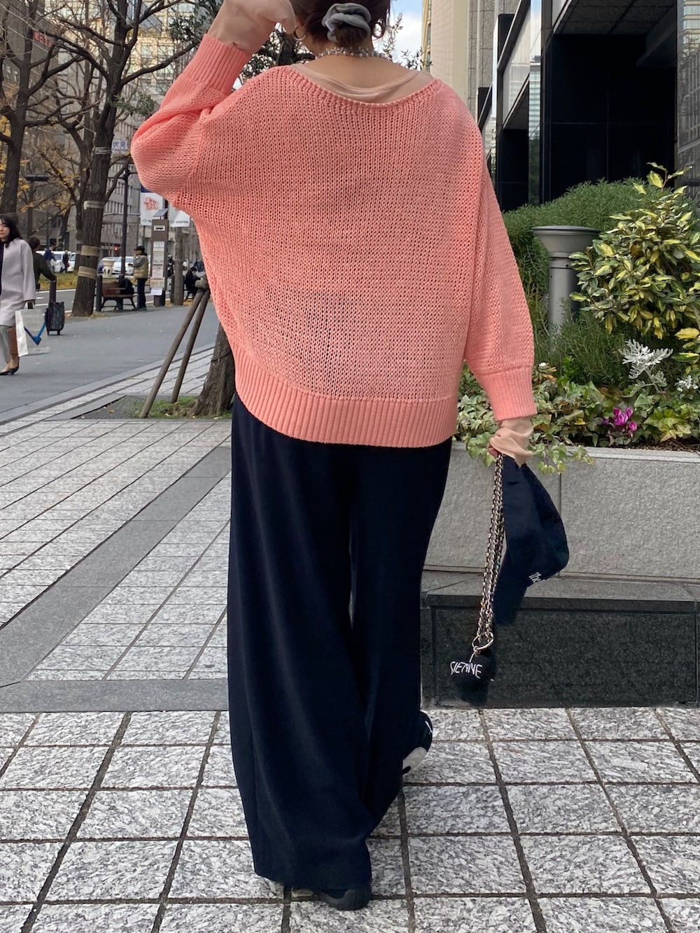 ピンク系のニット/セーター、ピンク系のTシャツ/カットソー、ブルー系のスラックスを着用したレディースの冬コーディネートの7枚目の写真