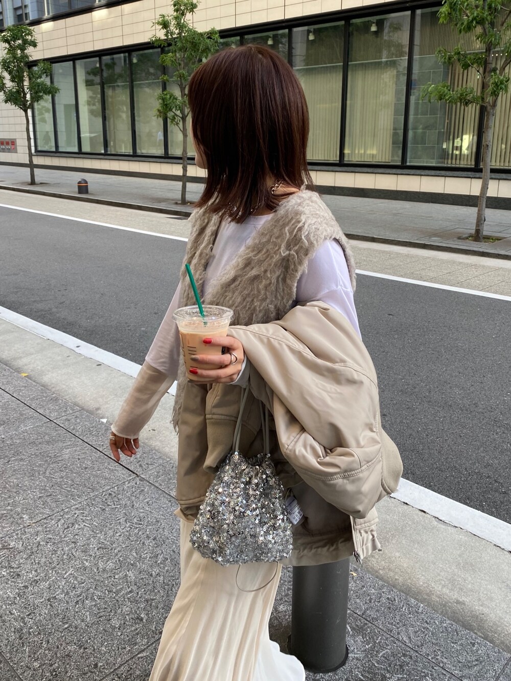 ベージュ系のMA-1、ベージュ系のベスト、ホワイト系のスカートを着用したレディースの秋コーディネートの5枚目の写真