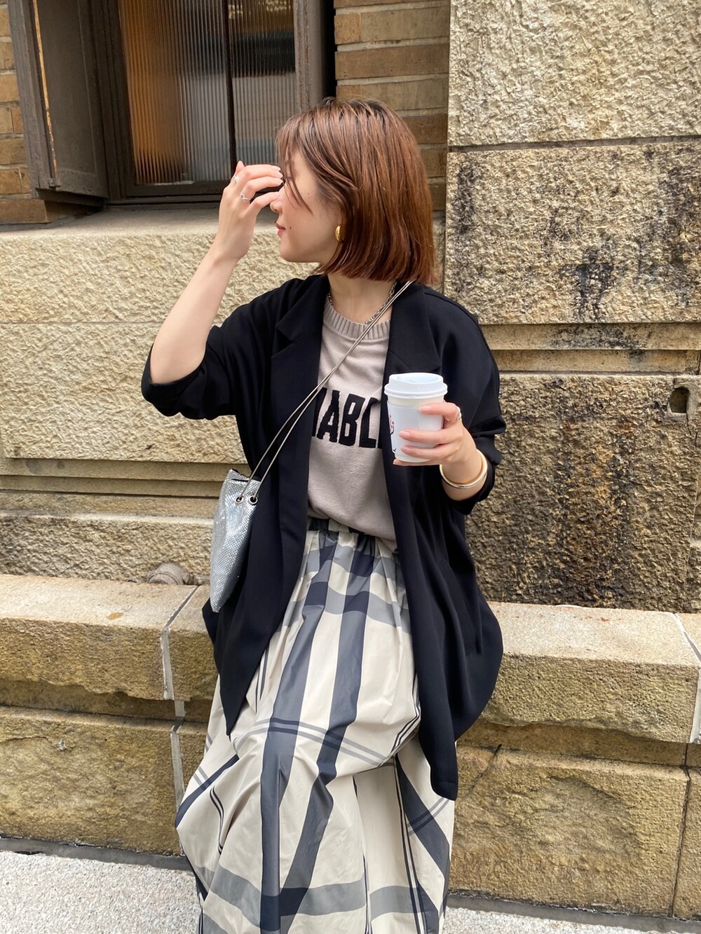 ベージュ系のニット/セーター、ベージュ系のスカート、ブラック系のサンダルを着用したレディースの冬コーディネートの4枚目の写真