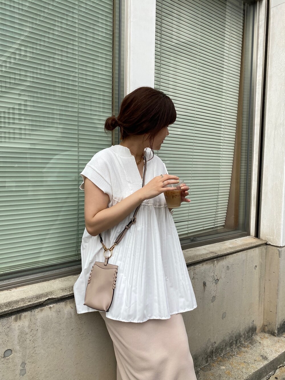 ホワイト系のニット/セーター、ベージュ系のスカート、ホワイト系のサンダルを着用したレディースの夏コーディネートの5枚目の写真