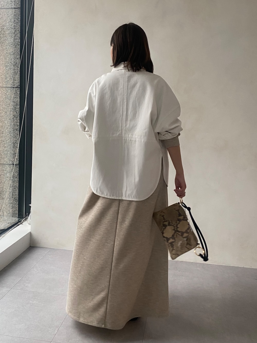 ホワイト系のシャツ/ブラウス、ベージュ系のワンピース、ブラック系のサンダルを着用したレディースの春コーディネートの3枚目の写真