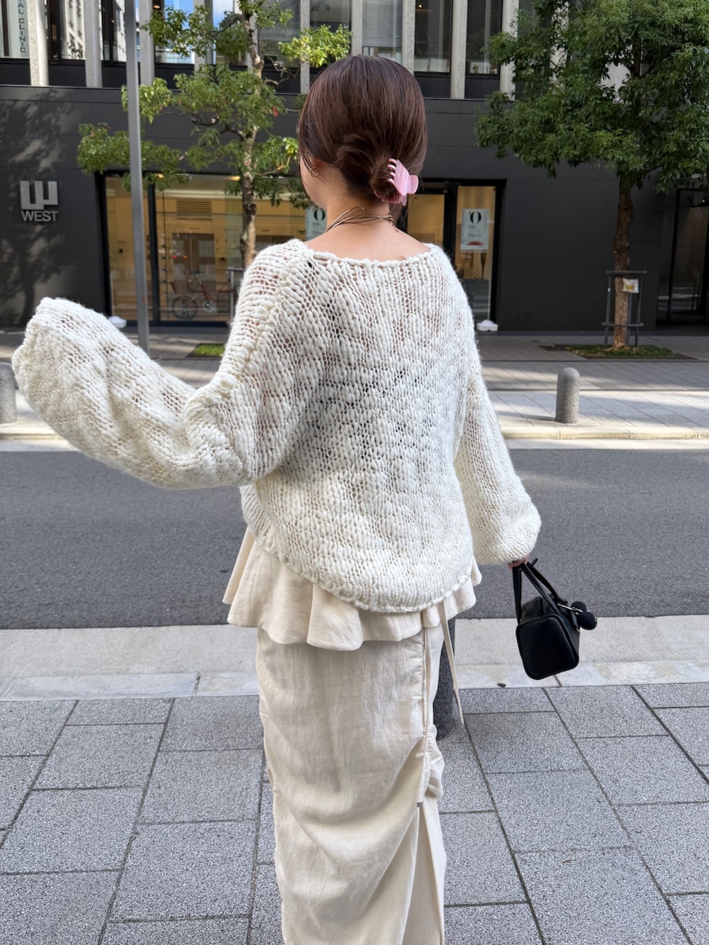 ホワイト系のニット/セーター、ホワイト系のスカート、ブラック系のトートバッグを着用したレディースの秋コーディネートの10枚目の写真