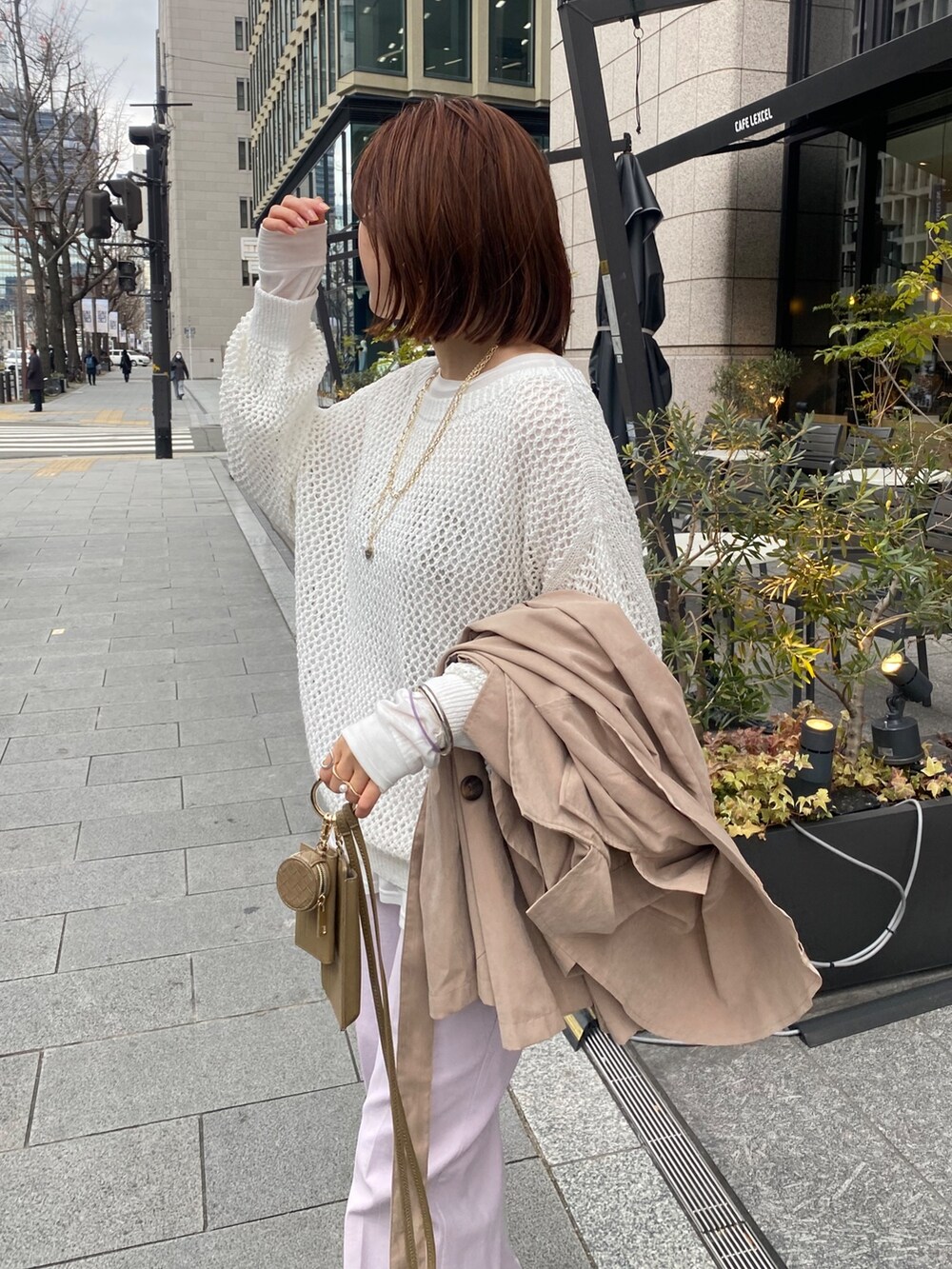 ホワイト系のニット/セーター、ホワイト系のTシャツ/カットソー、ピンク系のスラックスを着用したレディースの冬コーディネートの6枚目の写真