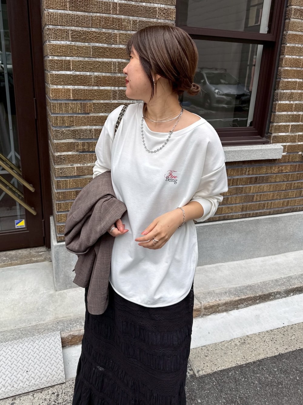 ホワイト系のTシャツ/カットソー、ブラック系のスカート、ブラウン系のテーラードジャケットを着用したレディースの冬コーディネートの6枚目の写真