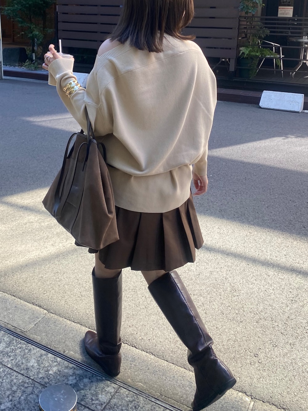 ベージュ系のニット/セーター、ブラウン系のスカート、ブラウン系のショルダーバッグを着用したレディースの冬コーディネートの6枚目の写真