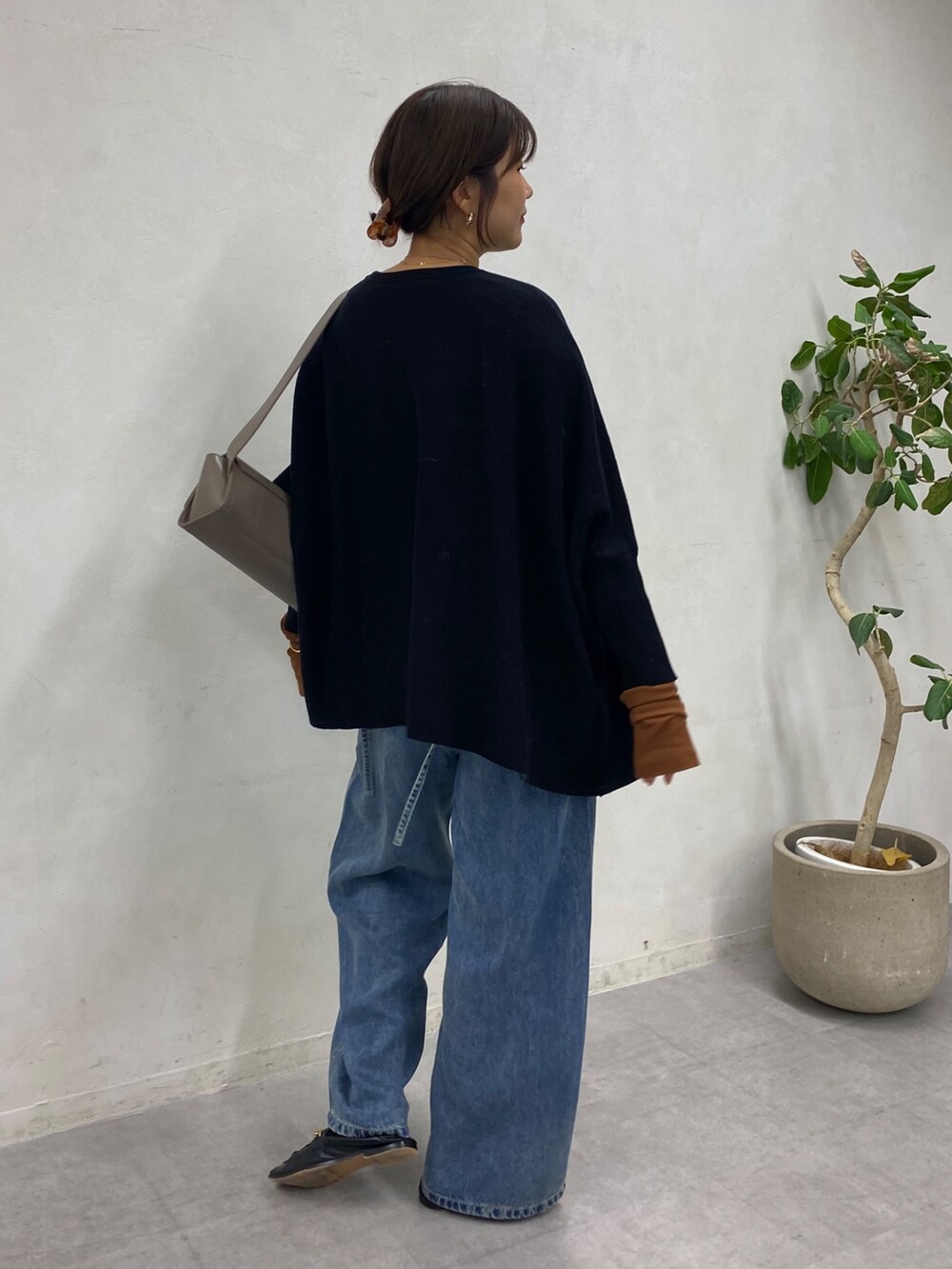 ブラック系のニット/セーター、ブルー系のデニムパンツ、ブラウン系のTシャツ/カットソーを着用したレディースの冬コーディネートの3枚目の写真