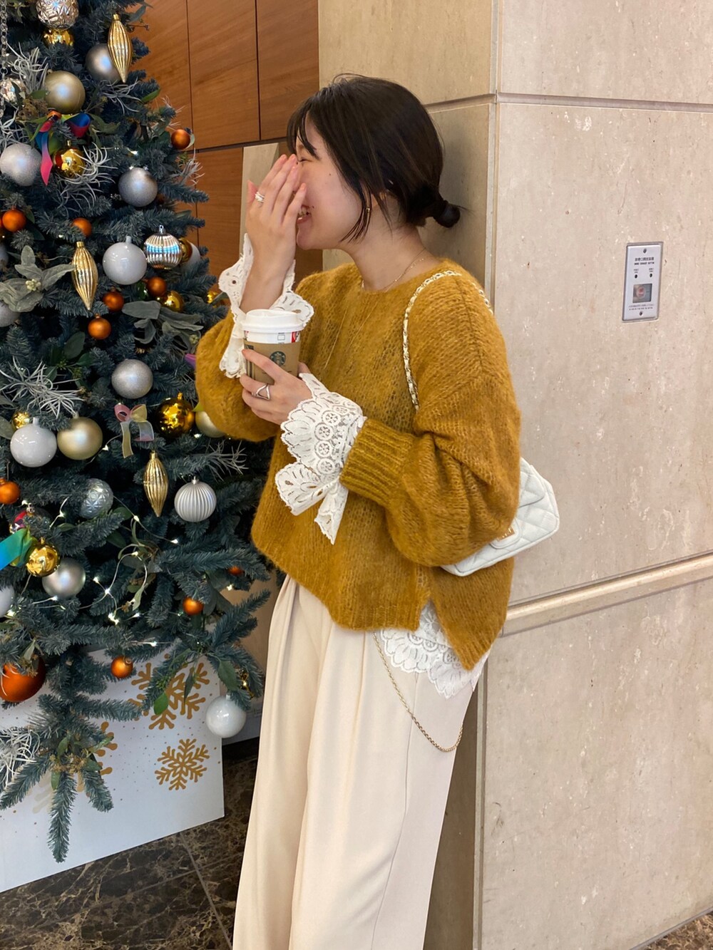 ベージュ系のその他アウター、イエロー系のニット/セーター、ホワイト系のシャツ/ブラウスを着用したレディースの冬コーディネートの2枚目の写真