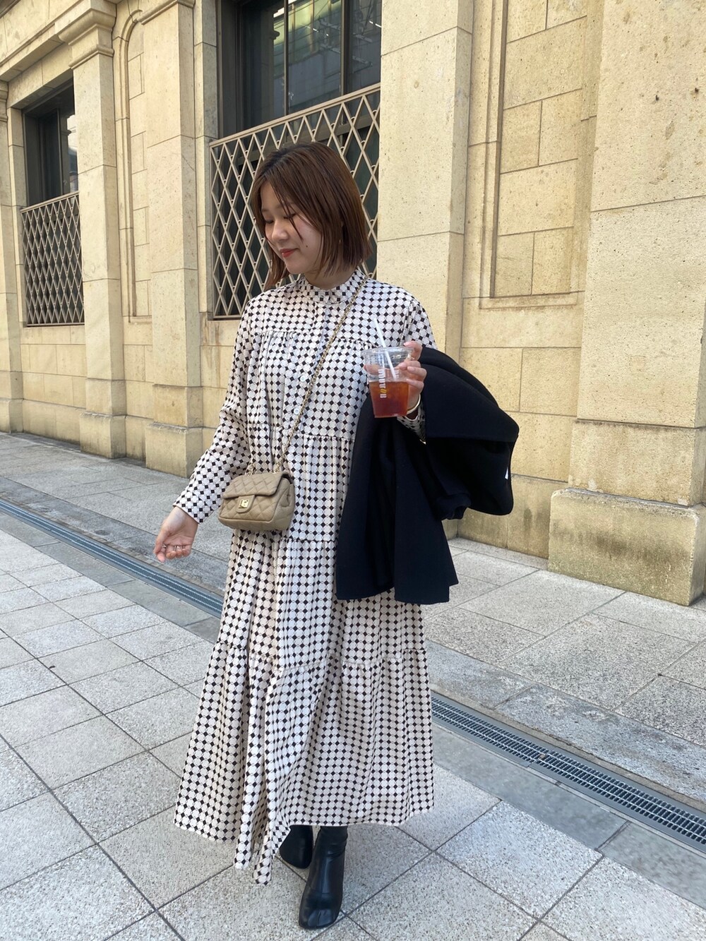 ベージュ系のワンピース、ブラック系のその他シューズ、ベージュ系のショルダーバッグを着用したレディースの冬コーディネートの5枚目の写真