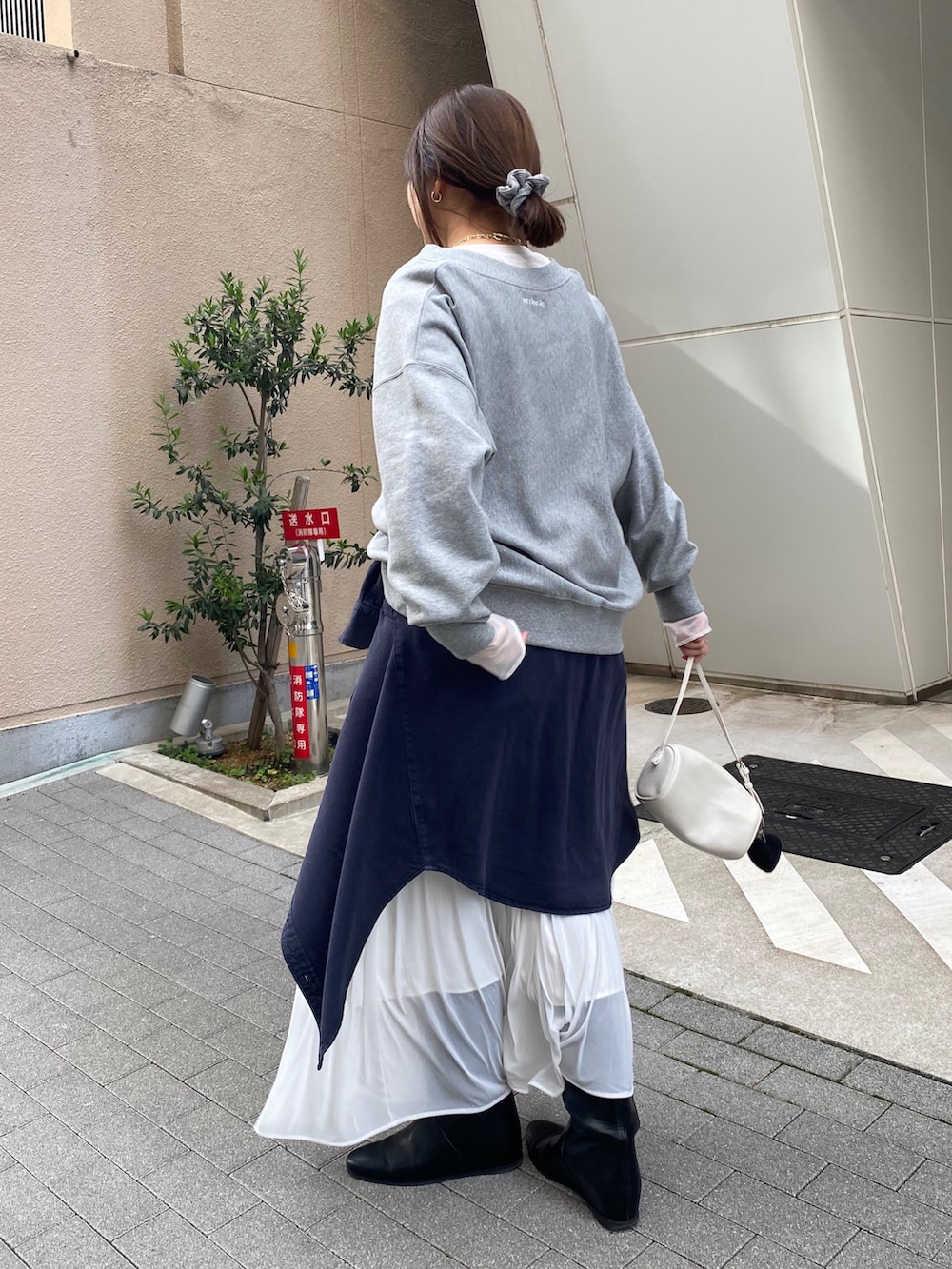 グレー系のスウェット、ブルー系のシャツ/ブラウス、ホワイト系のスカートを着用したレディースの冬コーディネートの10枚目の写真