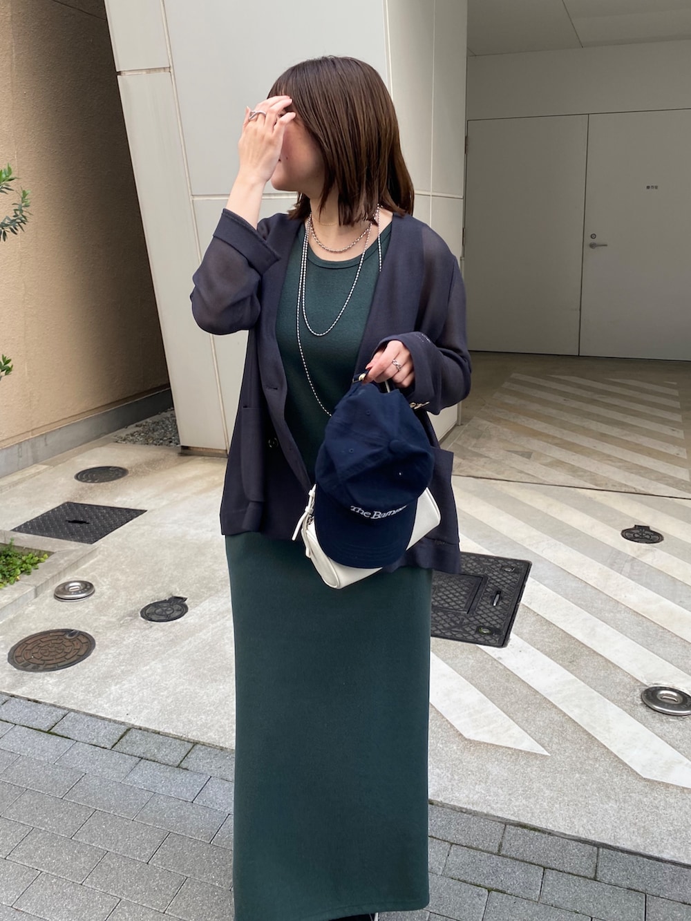 グレー系のテーラードジャケット、グリーン系のワンピースを着用したレディースの春コーディネートの6枚目の写真