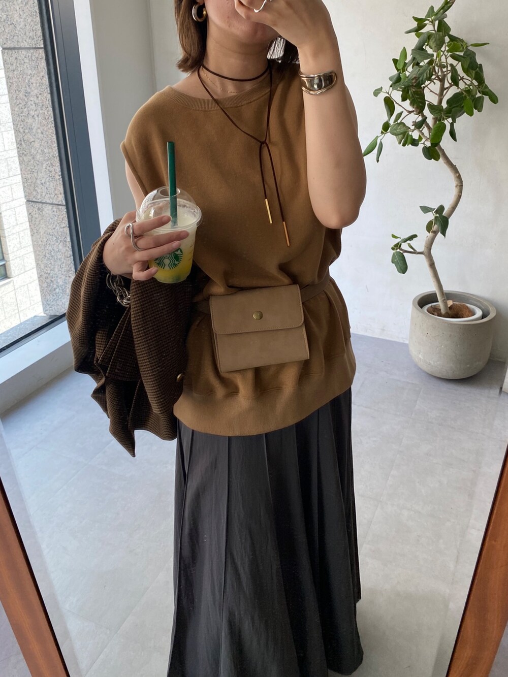 イエロー系のスウェット、グレー系のスカート、ブラウン系のテーラードジャケットを着用したレディースの夏コーディネートの5枚目の写真