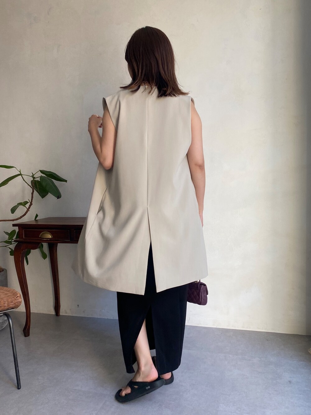 ベージュ系のベスト、ブラック系のワンピース、ブラック系のサンダルを着用したレディースの夏コーディネートの5枚目の写真