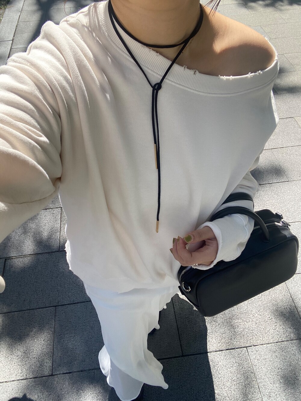 ホワイト系のTシャツ/カットソー、ホワイト系のスカート、ブラウン系のショルダーバッグを着用したレディースの冬コーディネートの5枚目の写真