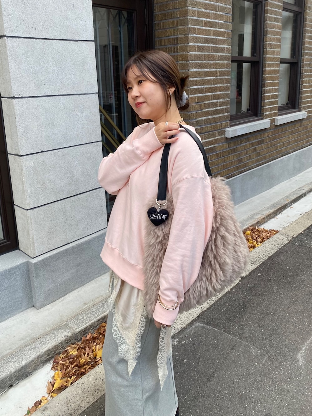 ピンク系のスウェット、ベージュ系のキャミソール、グレー系のスカートを着用したレディースの冬コーディネートの3枚目の写真