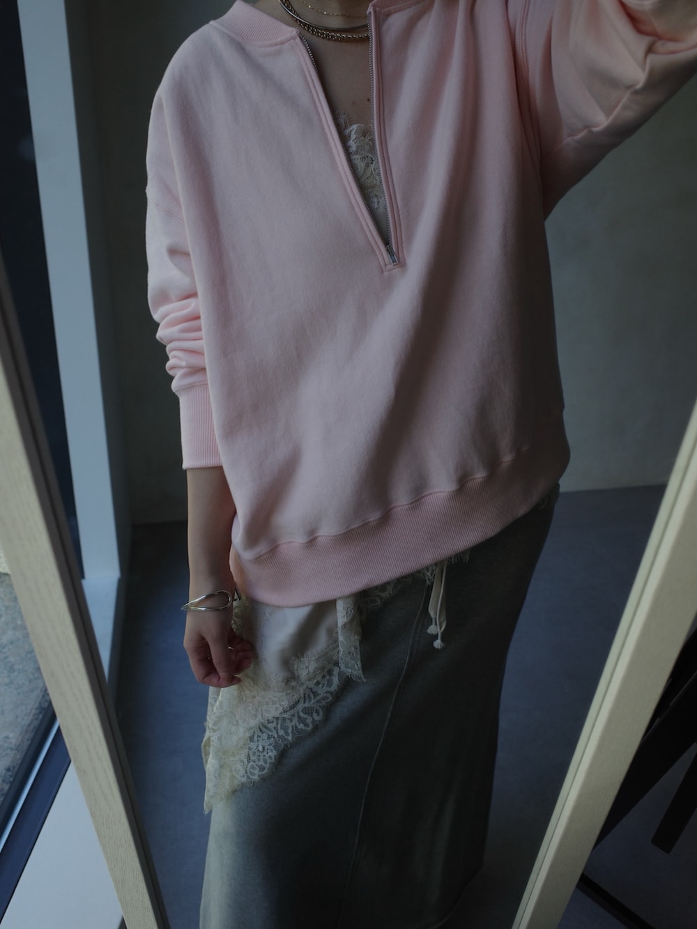 ピンク系のスウェット、ベージュ系のキャミソール、グレー系のスカートを着用したレディースの冬コーディネートの9枚目の写真