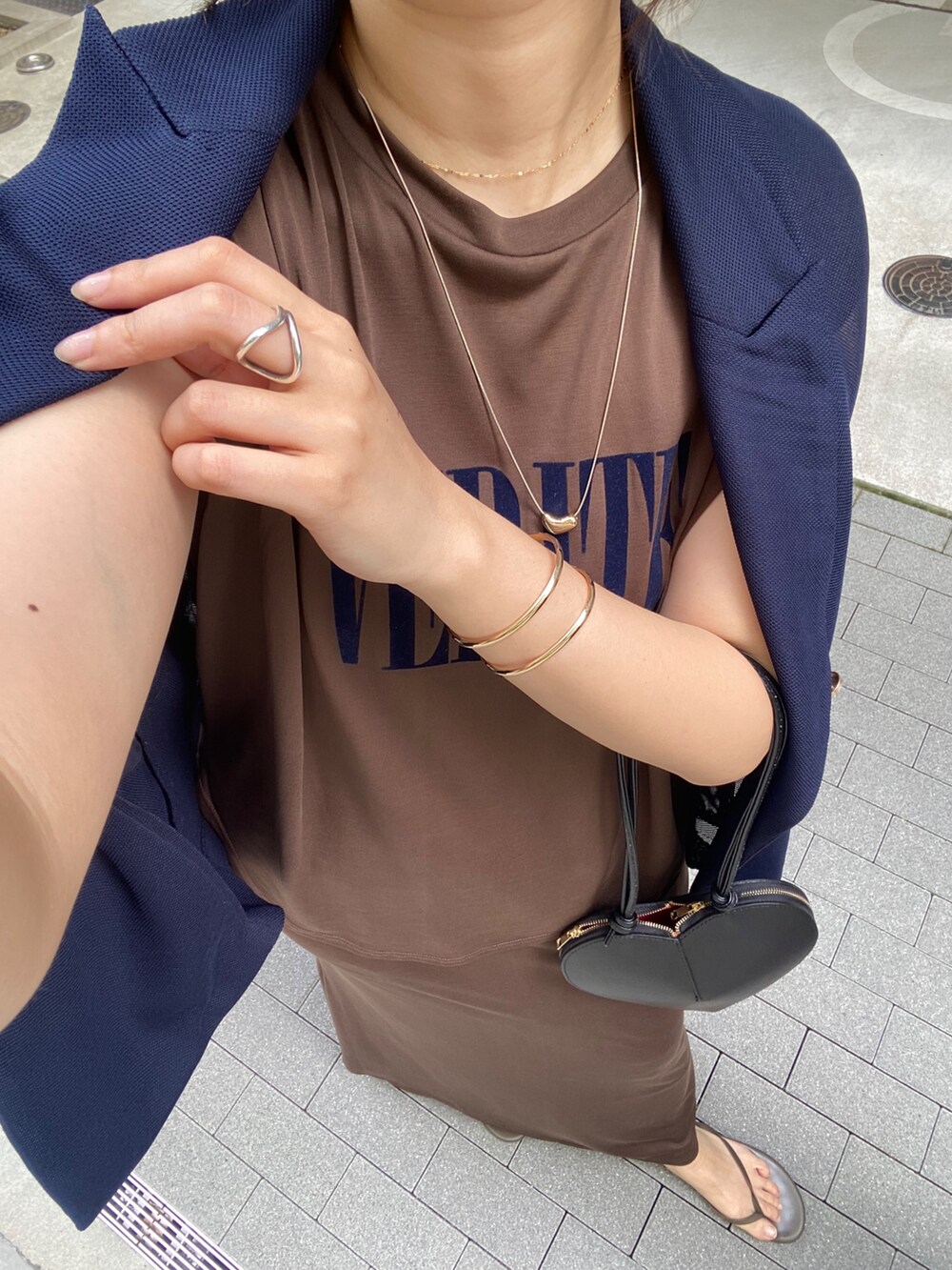 ブラウン系のTシャツ/カットソー、ブラウン系のスカート、ブラック系のショルダーバッグを着用したレディースの夏コーディネートの6枚目の写真