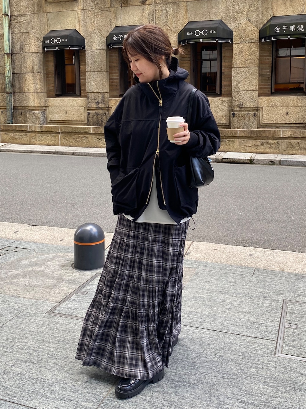 ブラック系のその他アウター、ホワイト系のTシャツ/カットソー、ブラック系のスカートを着用したレディースの春コーディネートの9枚目の写真