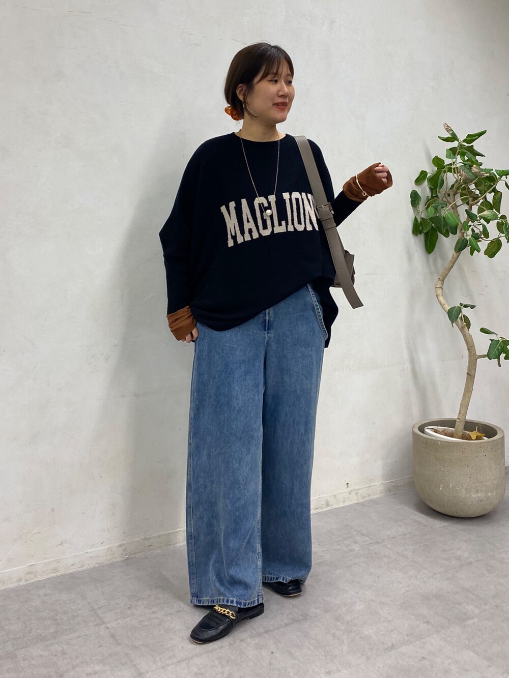 ブラック系のニット/セーター、ブルー系のデニムパンツ、ブラウン系のTシャツ/カットソーを着用したレディースの冬コーディネートの8枚目の写真