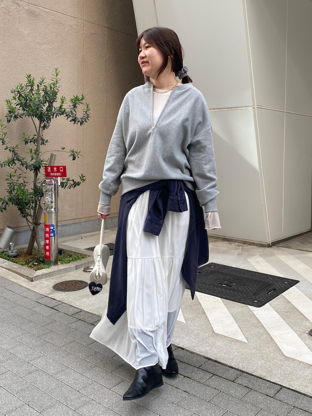 グレー系のスウェット、ブルー系のシャツ/ブラウス、ホワイト系のスカートを着用したレディースの冬コーディネートの9枚目の写真