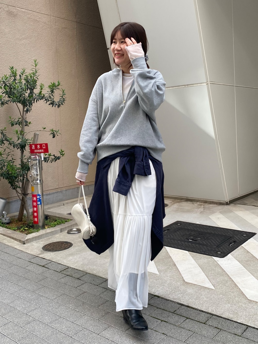 グレー系のスウェット、ブルー系のシャツ/ブラウス、ホワイト系のスカートを着用したレディースの冬コーディネートの7枚目の写真