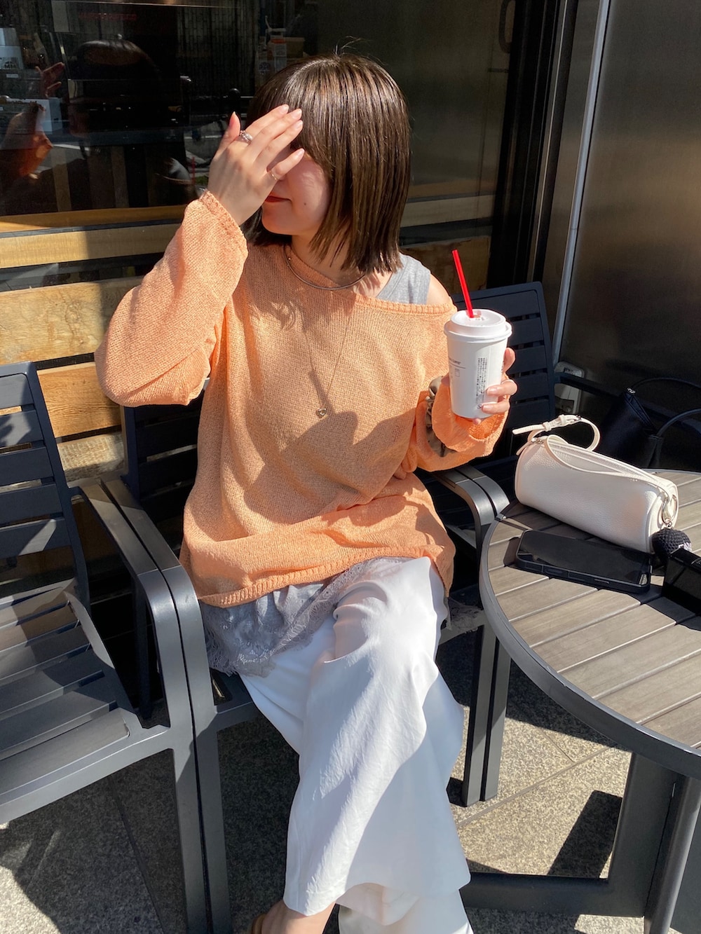 オレンジ系のニット/セーター、グレー系のTシャツ/カットソー、ホワイト系のその他パンツを着用したレディースの春コーディネートの9枚目の写真