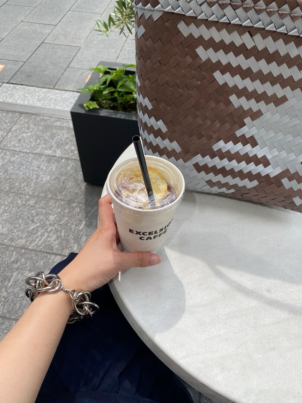 ブラウン系のシャツ/ブラウス、ブルー系のスカート、ブラウン系のショルダーバッグを着用したレディースの夏コーディネートの5枚目の写真