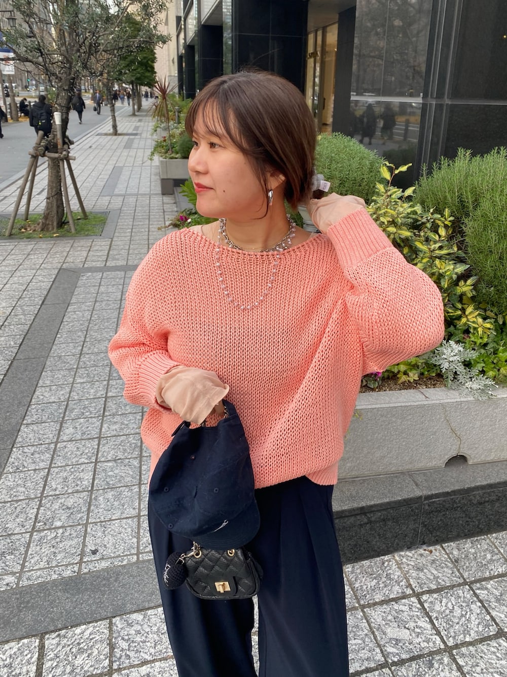 ピンク系のニット/セーター、ピンク系のTシャツ/カットソー、ブルー系のスラックスを着用したレディースの冬コーディネートの3枚目の写真