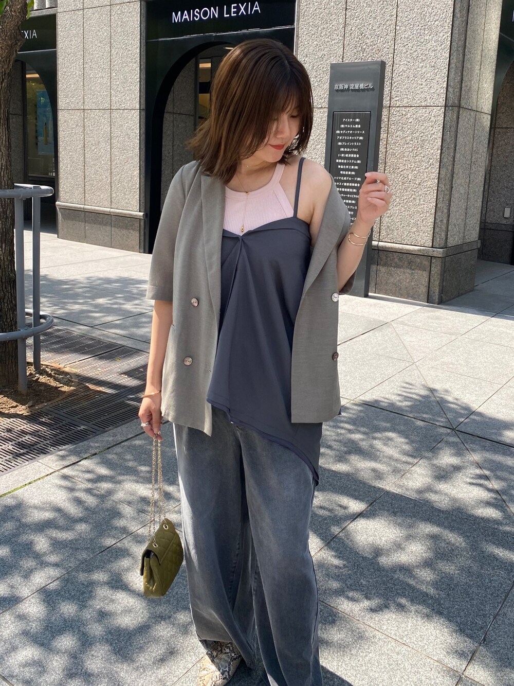 グレー系のテーラードジャケット、ブラック系のデニムパンツ、グレー系のシャツ/ブラウスを着用したレディースの夏コーディネートの2枚目の写真