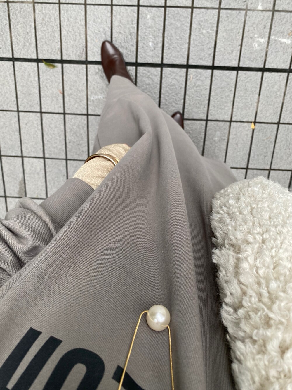 グレー系のワンピース、ブラウン系のブーツ、ゴールド系のTシャツ/カットソーを着用したレディースの秋コーディネートの10枚目の写真