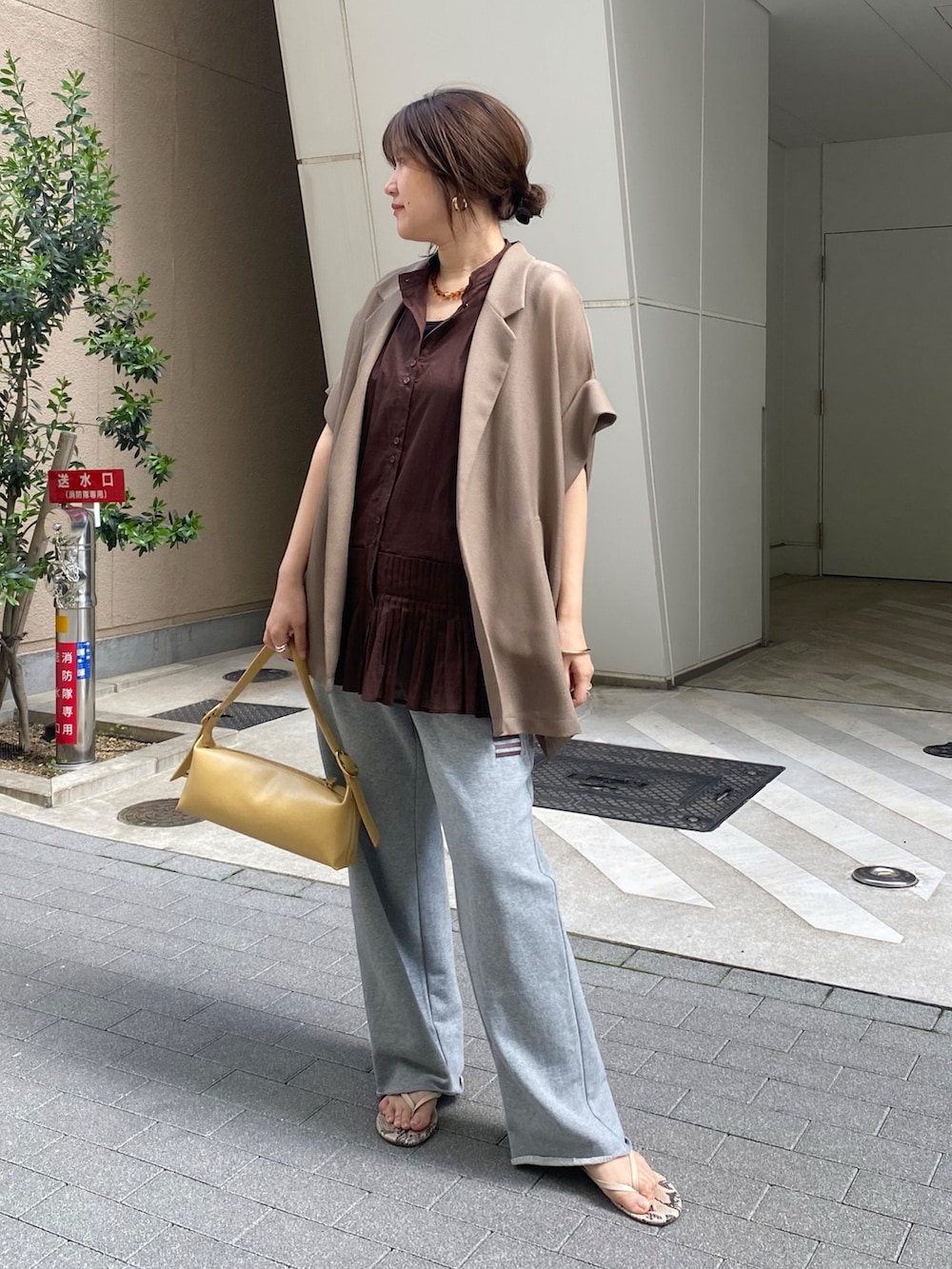 ブラウン系のシャツ/ブラウス、グレー系のその他パンツ、ブラウン系のテーラードジャケットを着用したレディースの春コーディネートの3枚目の写真