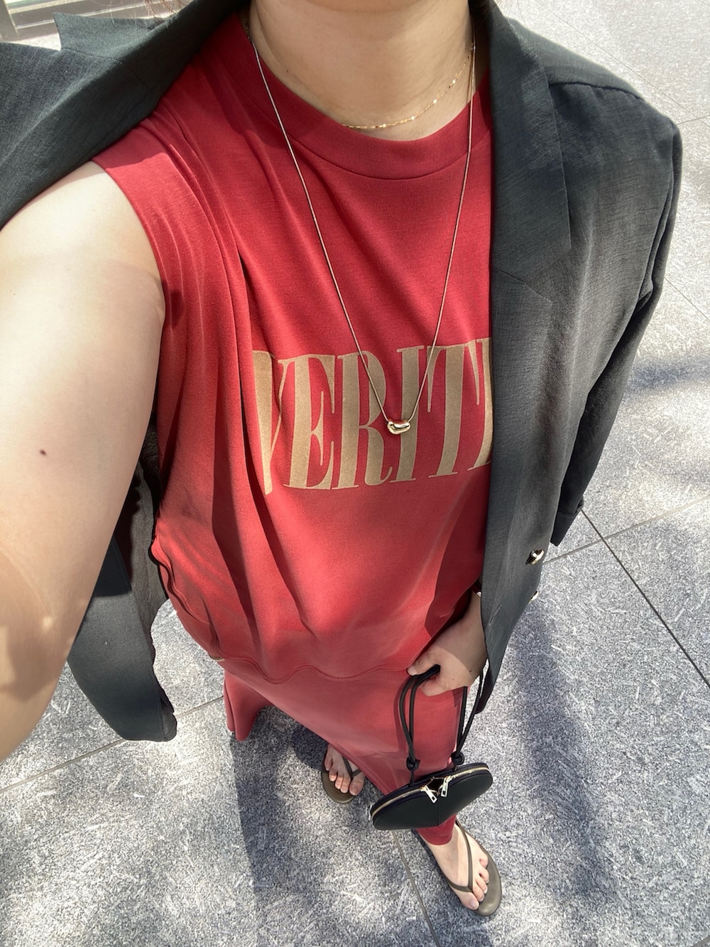 グレー系のテーラードジャケット、レッド系のTシャツ/カットソー、ブラック系のショルダーバッグを着用したレディースの春コーディネートの4枚目の写真