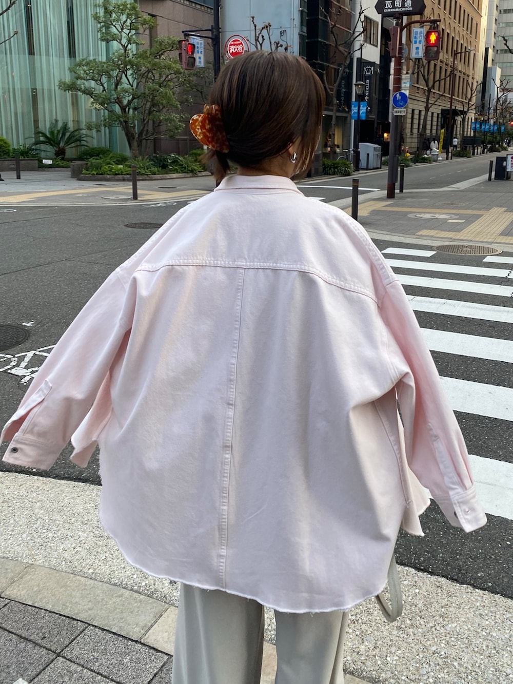 ピンク系のシャツ/ブラウス、ピンク系のTシャツ/カットソー、グレー系のスラックスを着用したレディースの冬コーディネートの8枚目の写真