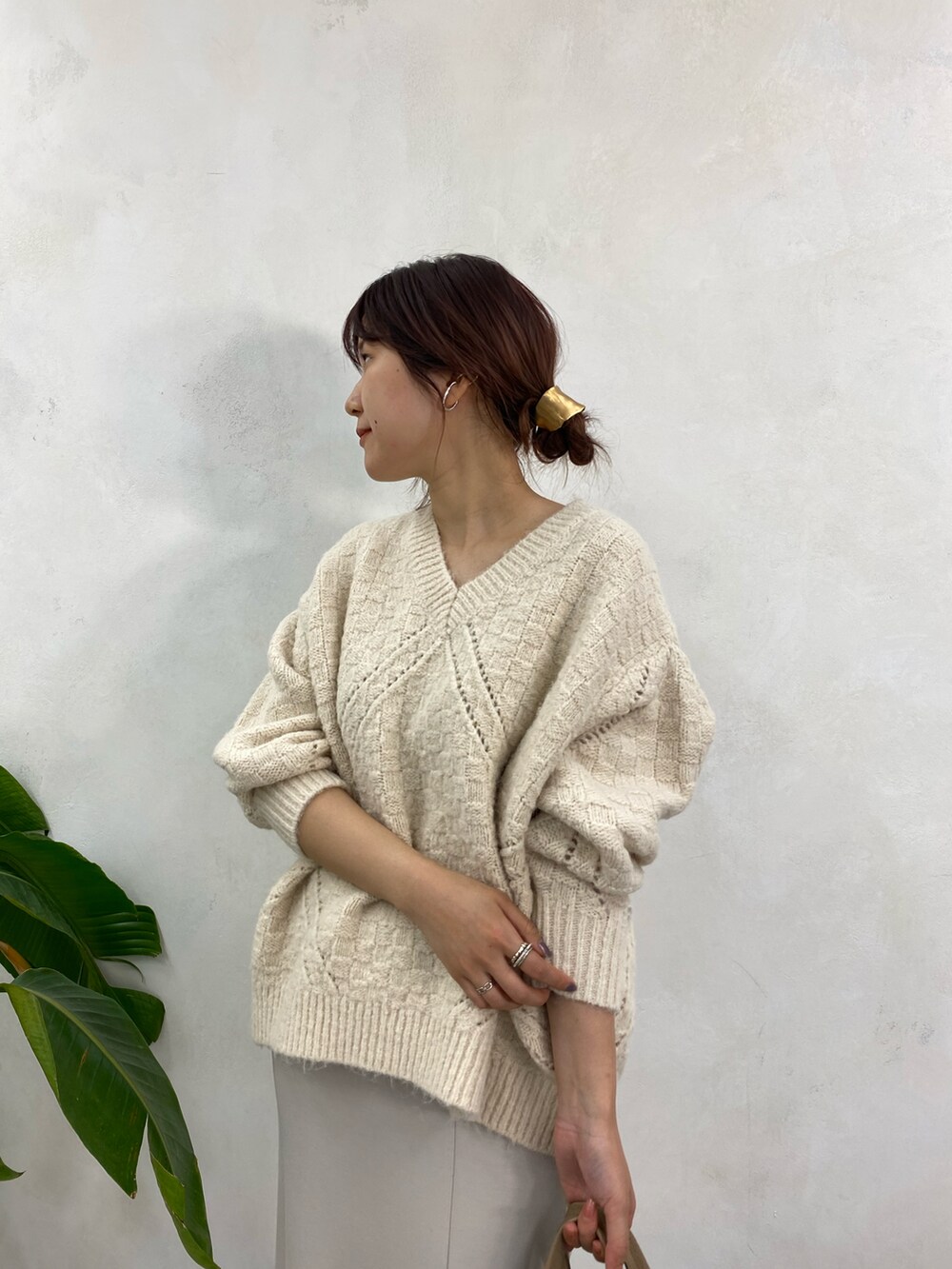 ホワイト系のニット/セーター、ベージュ系のトートバッグ、ベージュ系のスカートを着用したレディースの冬コーディネートの3枚目の写真