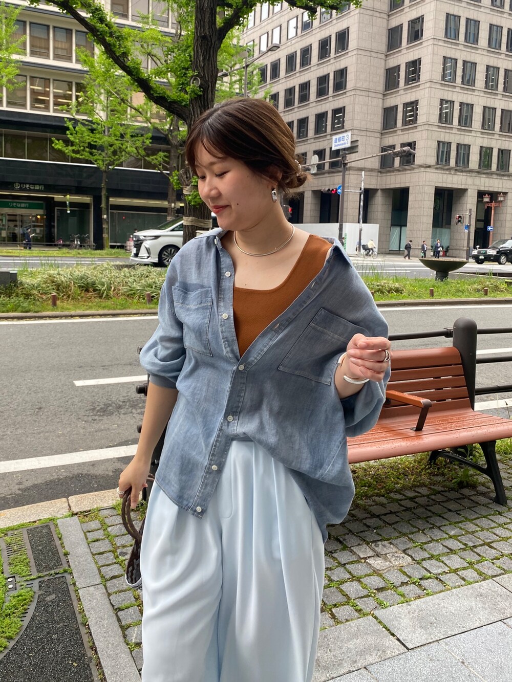 ブルー系のシャツ/ブラウス、ブラウン系のタンクトップ、ブルー系のスラックスを着用したレディースの春コーディネートの2枚目の写真