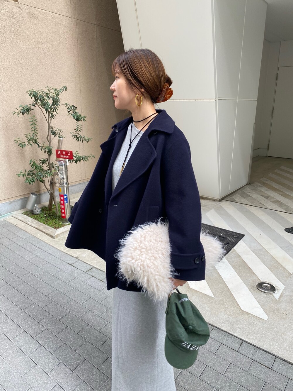 シルバー系のスウェット、シルバー系のスカート、ブラック系のブーツを着用したレディースの秋コーディネートの5枚目の写真