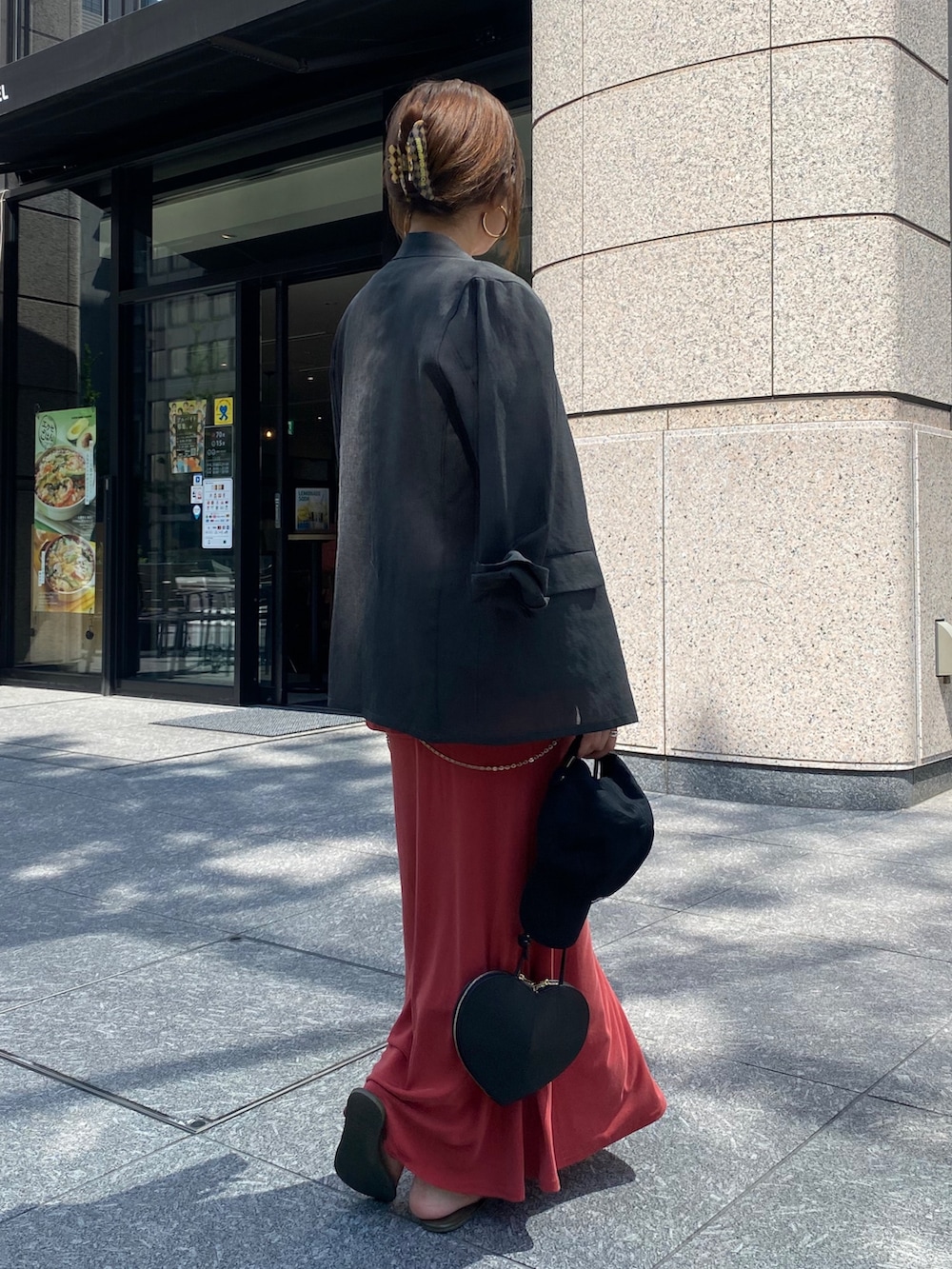 グレー系のテーラードジャケット、レッド系のTシャツ/カットソー、ブラック系のショルダーバッグを着用したレディースの春コーディネートの2枚目の写真