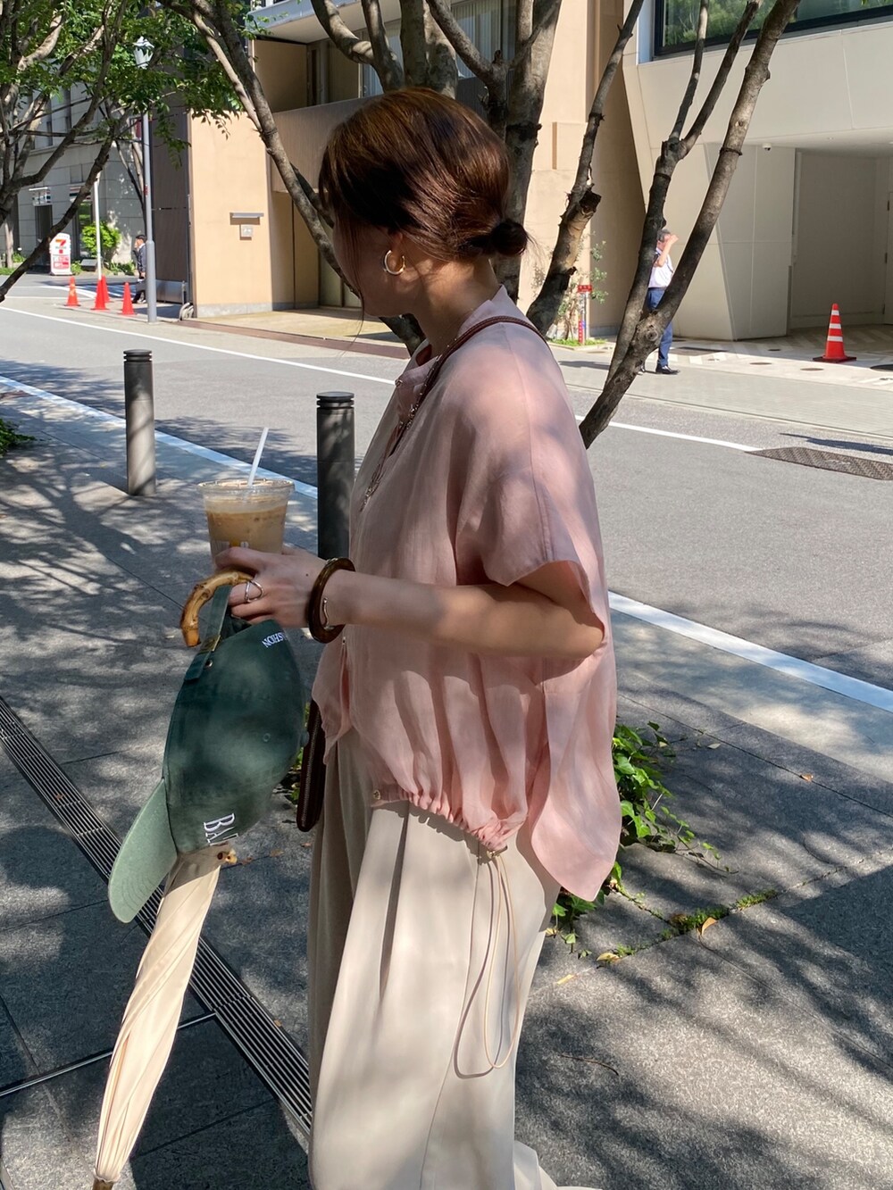 ピンク系のシャツ/ブラウス、ホワイト系のスラックス、ゴールド系のネックレスを着用したレディースの夏コーディネートの4枚目の写真