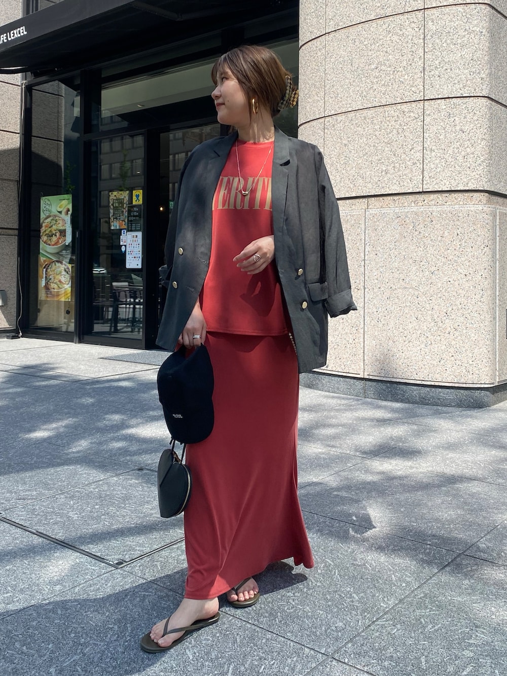 グレー系のテーラードジャケット、レッド系のTシャツ/カットソー、ブラック系のショルダーバッグを着用したレディースの春コーディネートの3枚目の写真