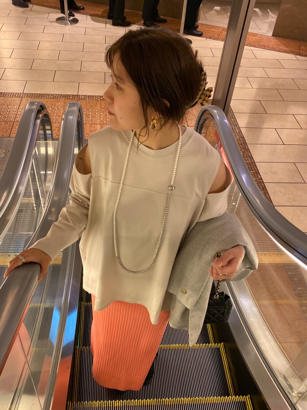 ピンク系のスカート、グレー系のテーラードジャケット、ブルー系のショルダーバッグを着用したレディースの冬コーディネートの7枚目の写真