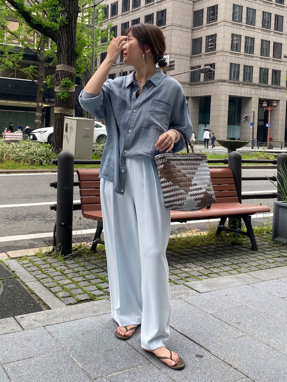 ブルー系のシャツ/ブラウス、ブラウン系のタンクトップ、ブルー系のスラックスを着用したレディースの春コーディネートの6枚目の写真