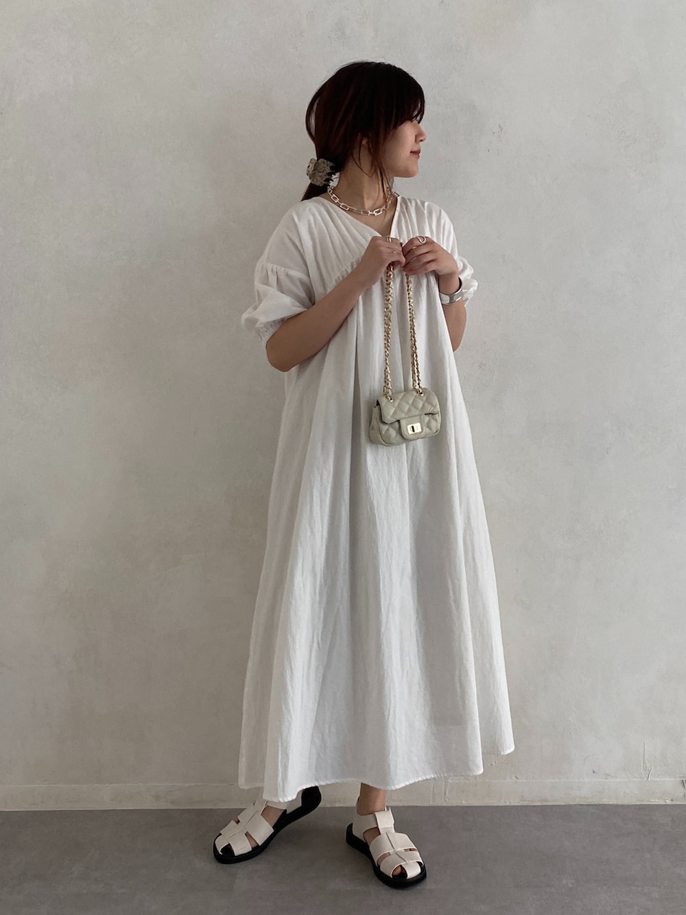 ホワイト系のワンピース、ブラック系のその他シューズ、ホワイト系のショルダーバッグを着用したレディースの夏コーディネートの2枚目の写真