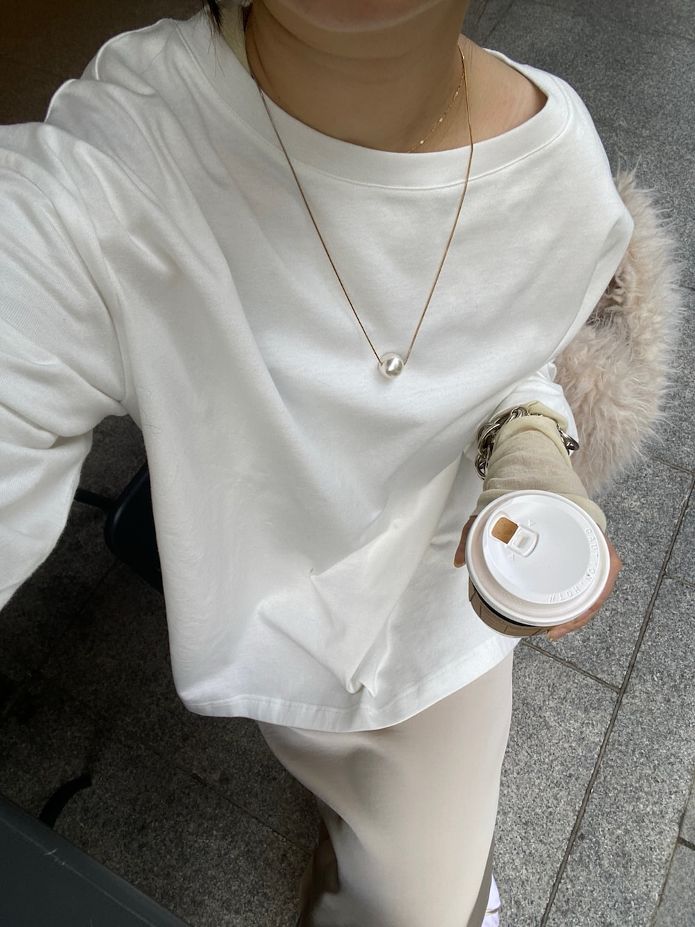 ホワイト系のTシャツ/カットソー、ベージュ系のスカート、イエロー系のTシャツ/カットソーを着用したレディースの冬コーディネートの10枚目の写真