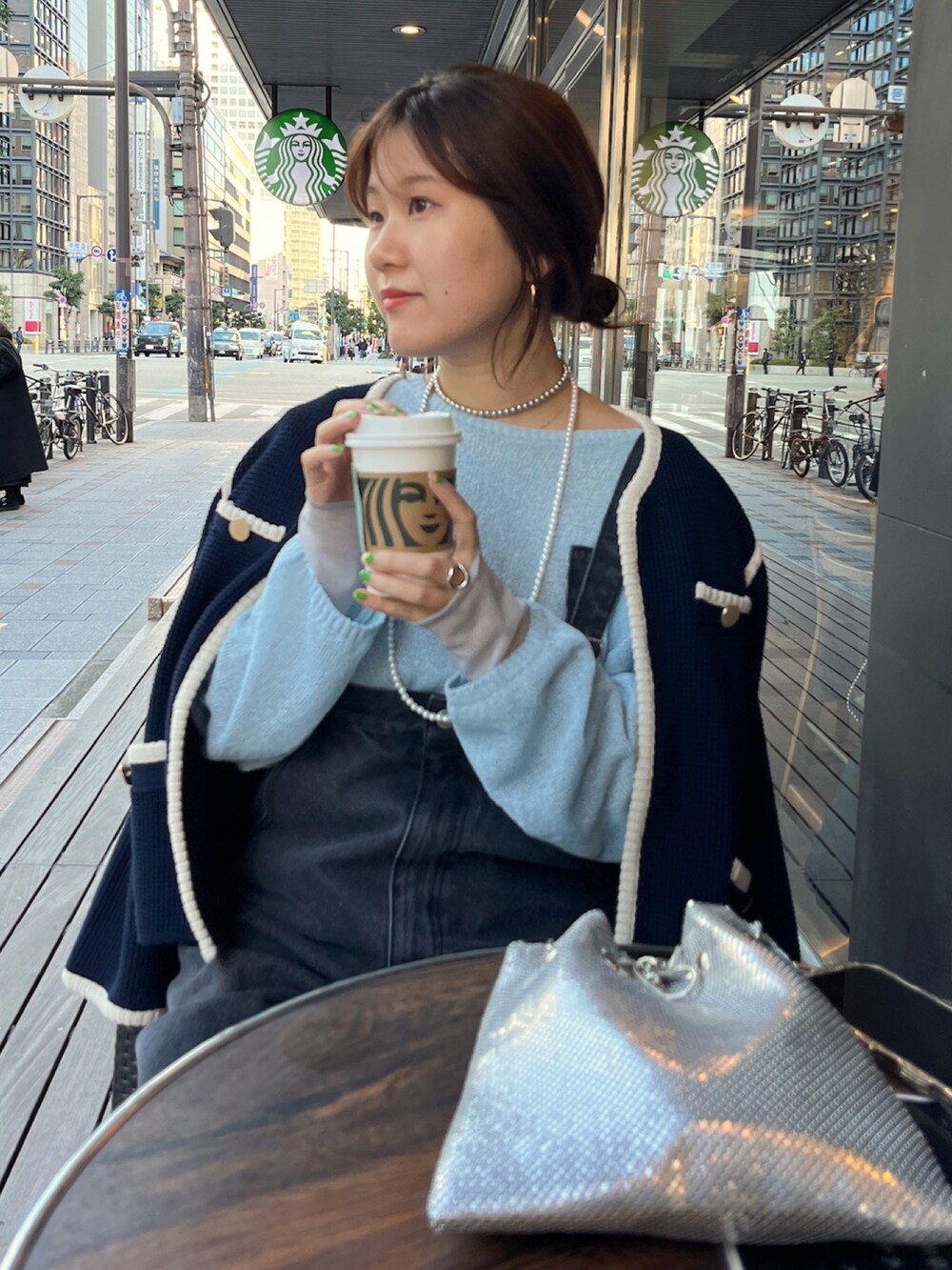 ブルー系のノーカラージャケット、ブラック系のサロペット/オーバーオール、ゴールド系のショルダーバッグを着用したレディースの冬コーディネートの7枚目の写真