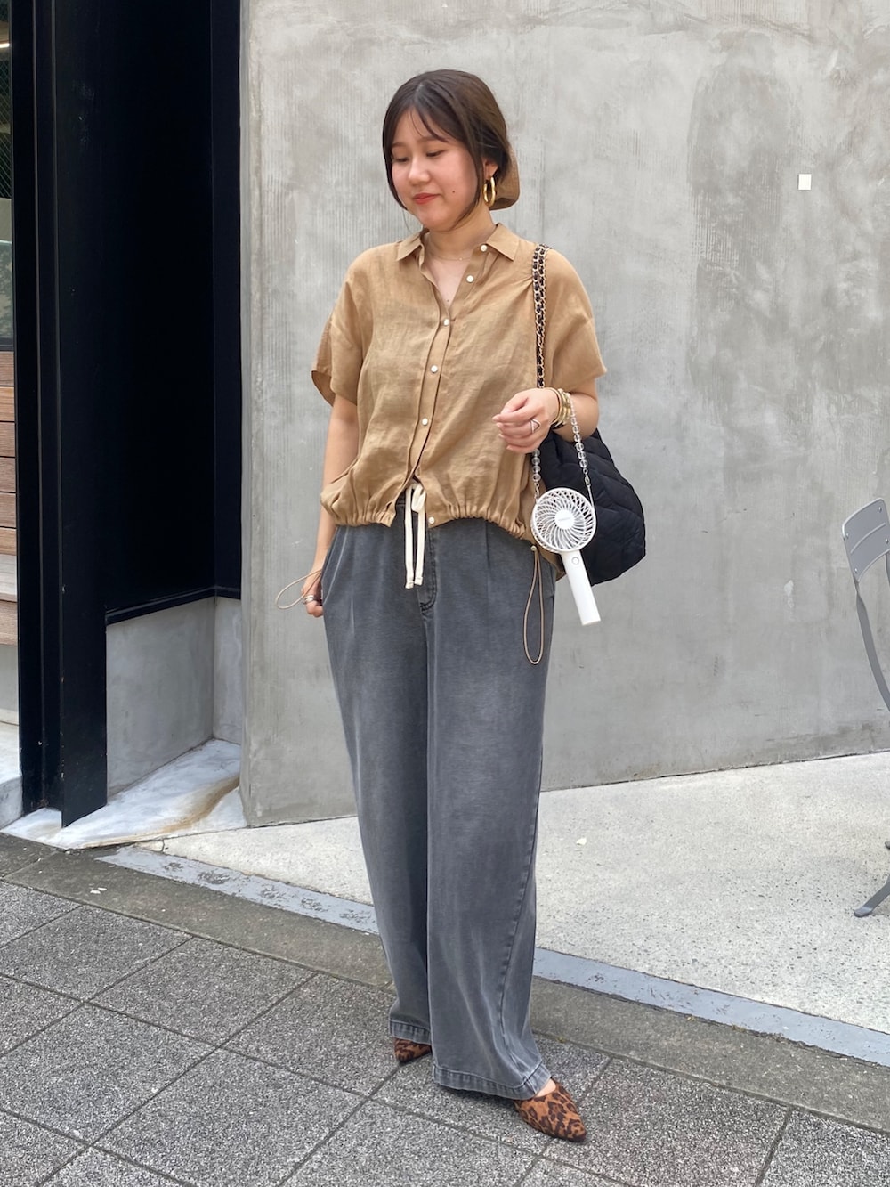 ベージュ系のシャツ/ブラウス、ブラック系のデニムパンツ、ブラウン系のシュシュを着用したレディースの夏コーディネートの2枚目の写真