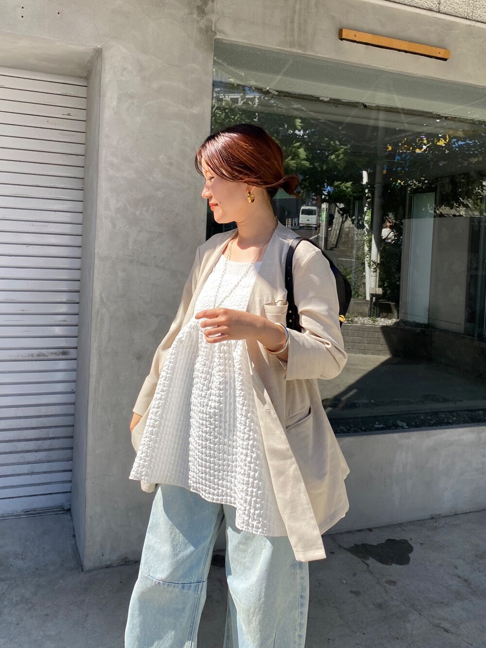 ホワイト系のキャミソール、ブルー系のデニムパンツ、ブラック系のショルダーバッグを着用したレディースの夏コーディネートの8枚目の写真