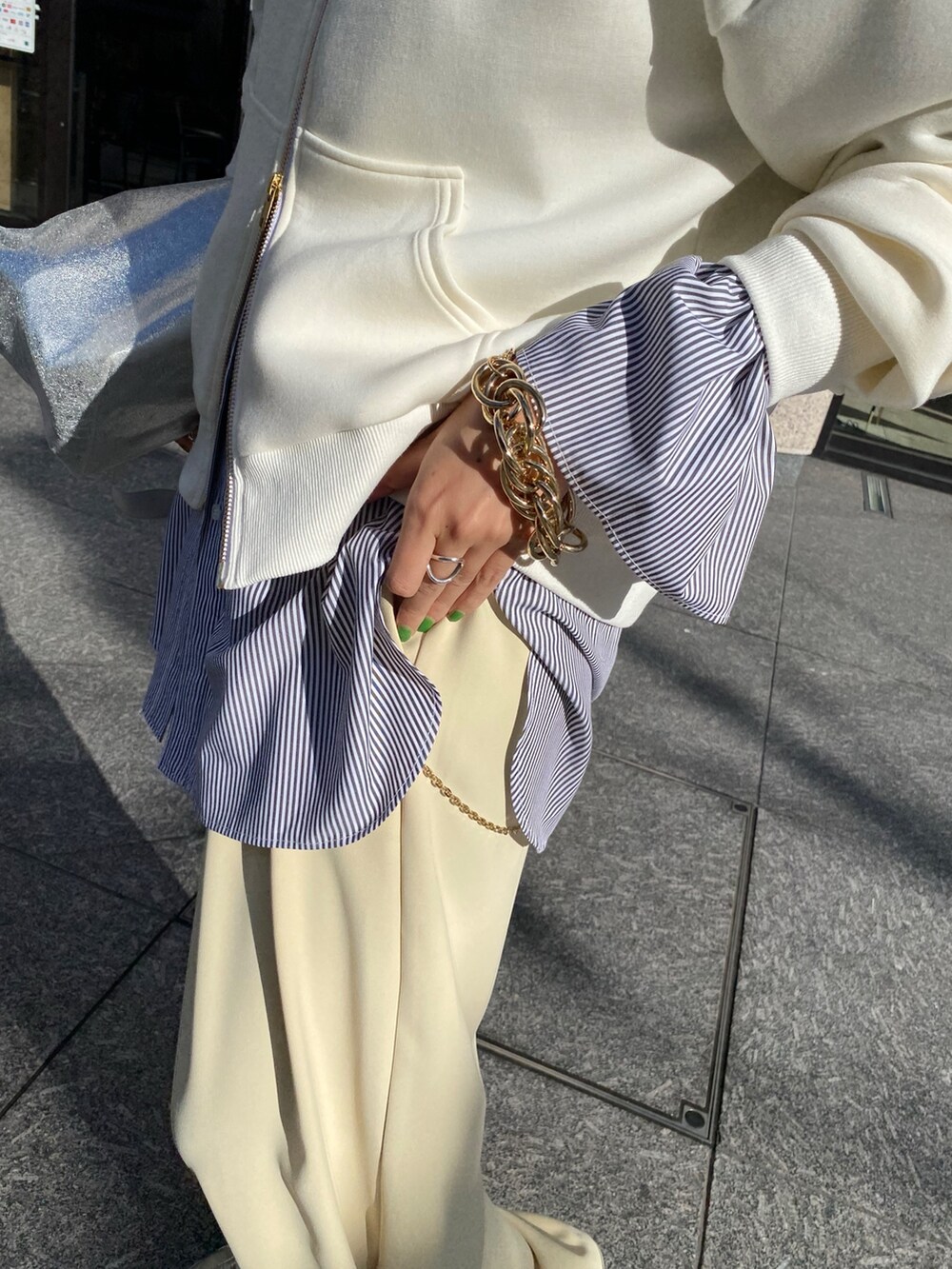 ホワイト系のパーカー、ブラック系のシャツ/ブラウス、イエロー系のスラックスを着用したレディースの冬コーディネートの5枚目の写真